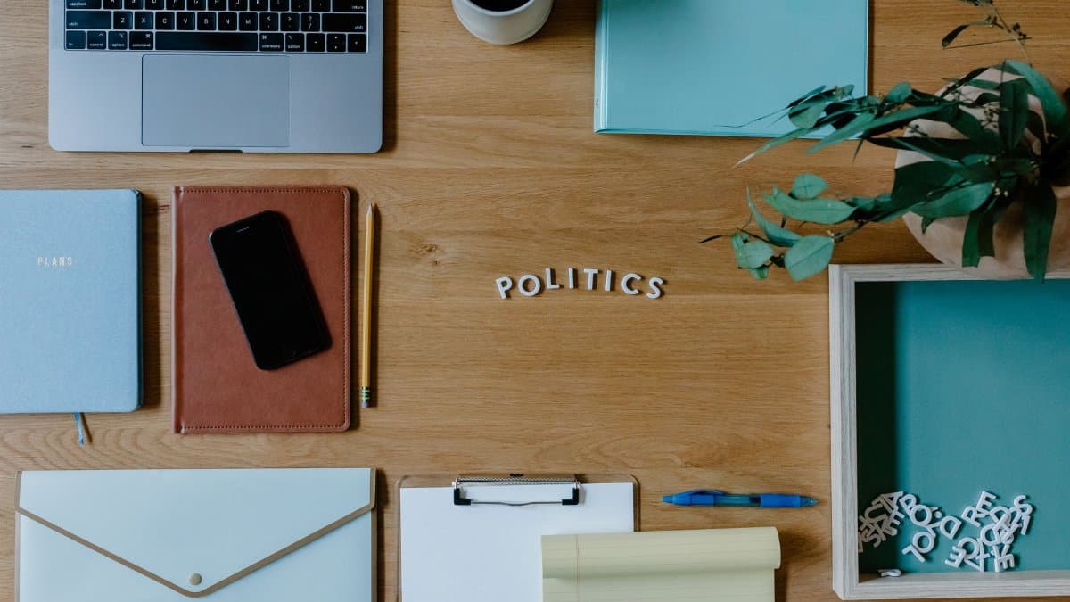Stylish flat lay of office workspace featuring political themes and modern accessories.