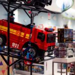 Vibrant display of toy vehicles in a toy store, featuring a bright red fire truck labeled 911.