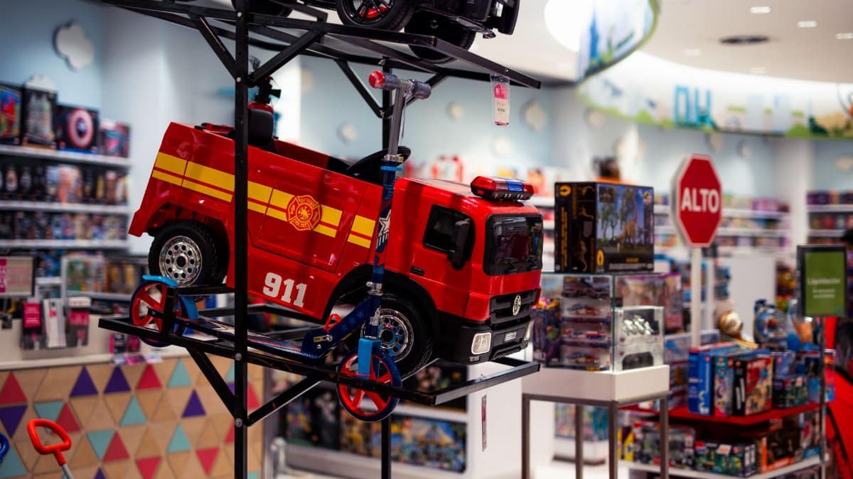 Vibrant display of toy vehicles in a toy store, featuring a bright red fire truck labeled 911.