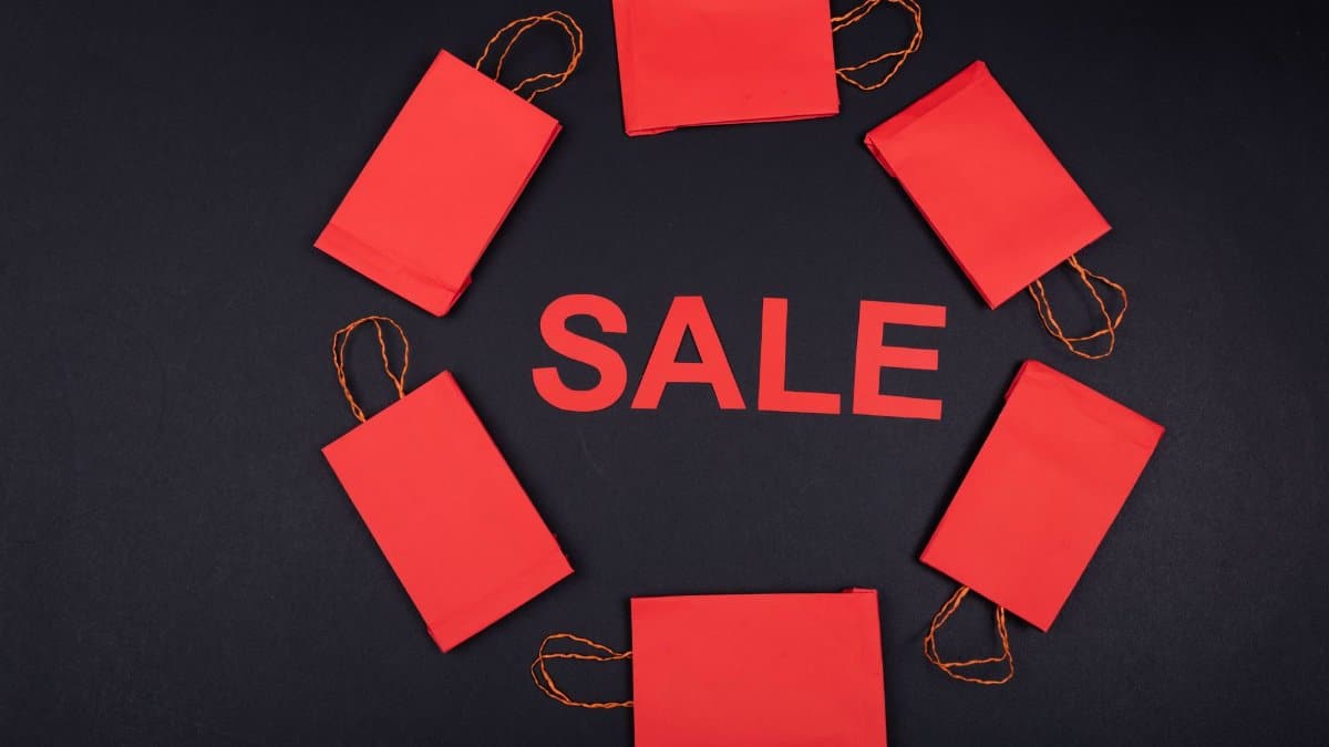 Circular arrangement of red paper bags with 'SALE' text on a dark background.