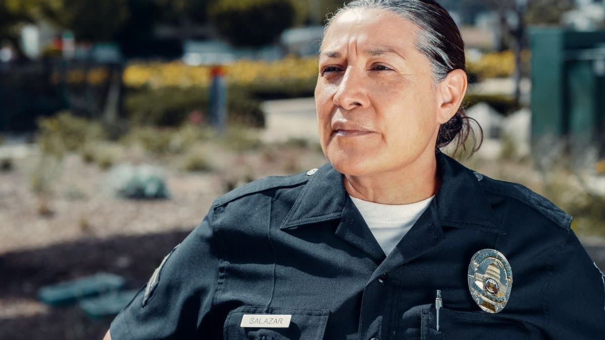 Portrait of a female police officer standing confidently outdoors in uniform.