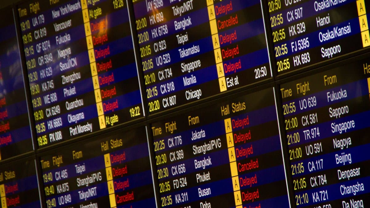 Close-up of digital flight information board showing arrivals and departures at an airport.