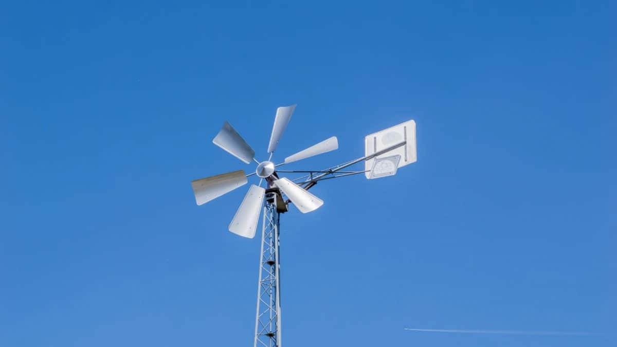 A traditional windmill stands tall against a clear blue sky, symbolizing renewable energy.
