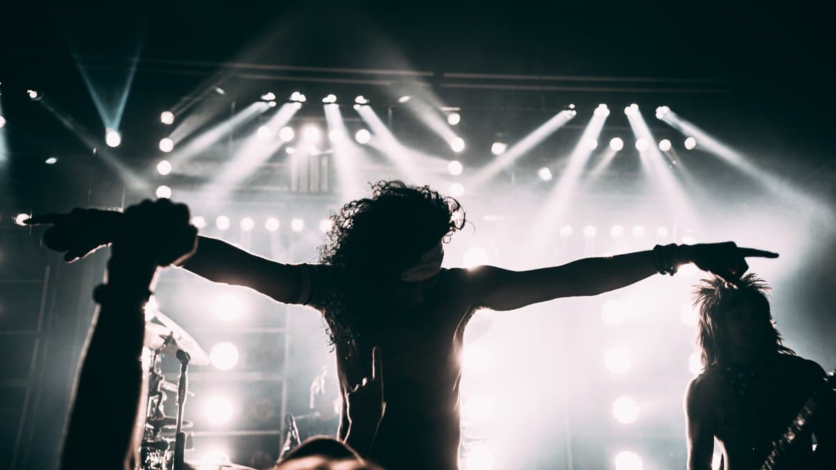 Energetic rock band performance with striking stage lights and silhouettes.