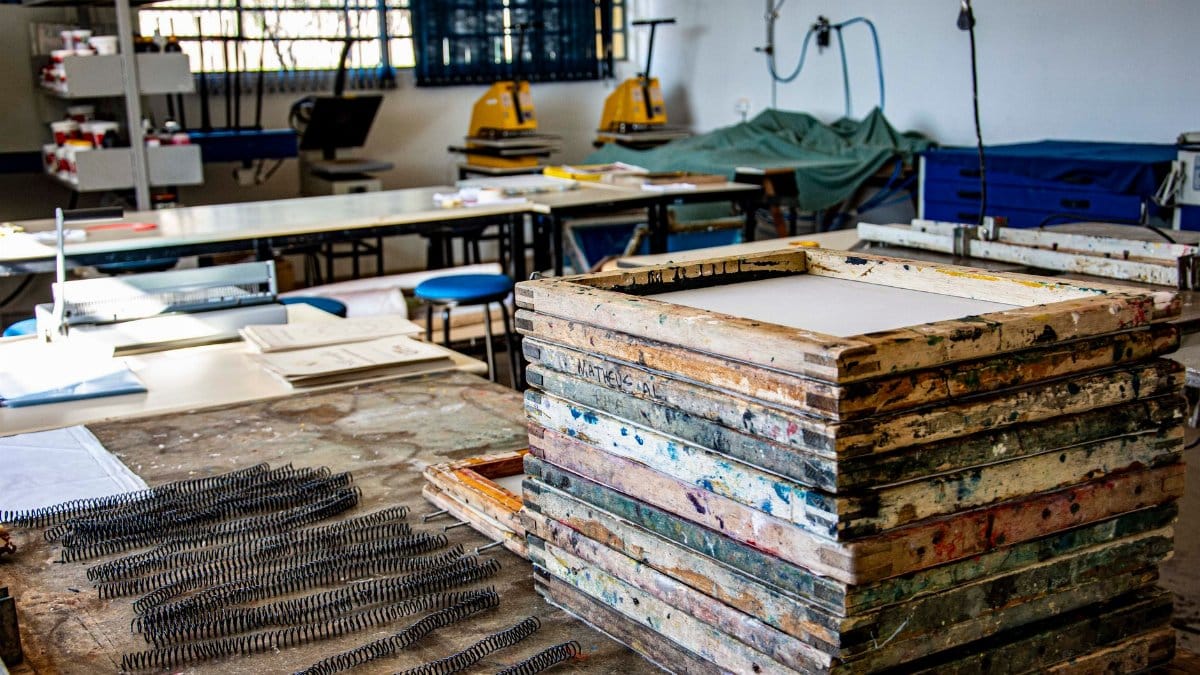 Interior of a textile workshop in Apucarana, highlighting screen printing frames and equipment.
