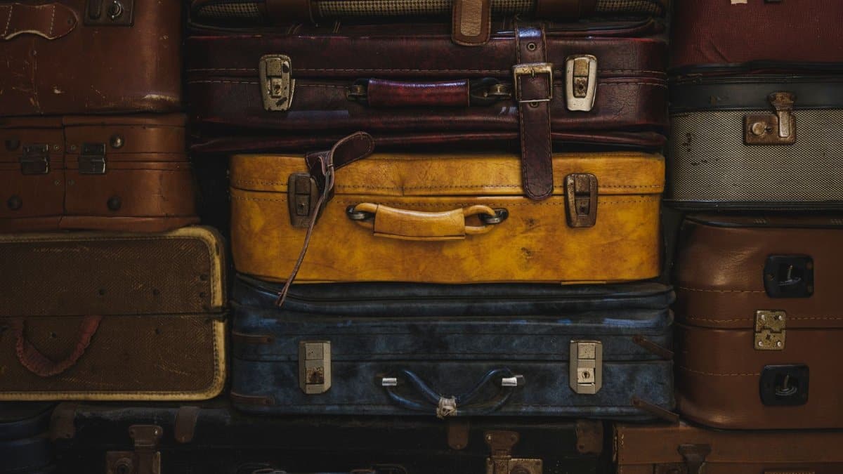 Vintage suitcases stacked in a rustic setting, showcasing classic travel charm.