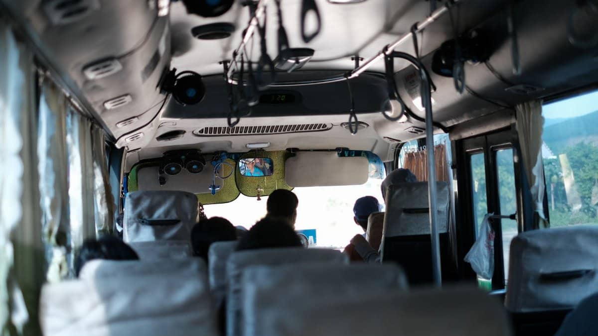 A typical day inside a Vietnamese bus with passengers traveling and scenic views outside.