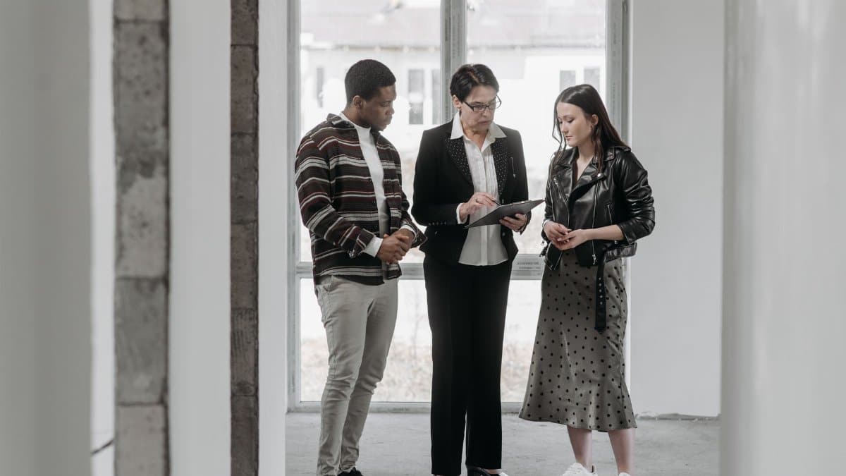 A real estate agent discusses property details with potential buyers during a house viewing.