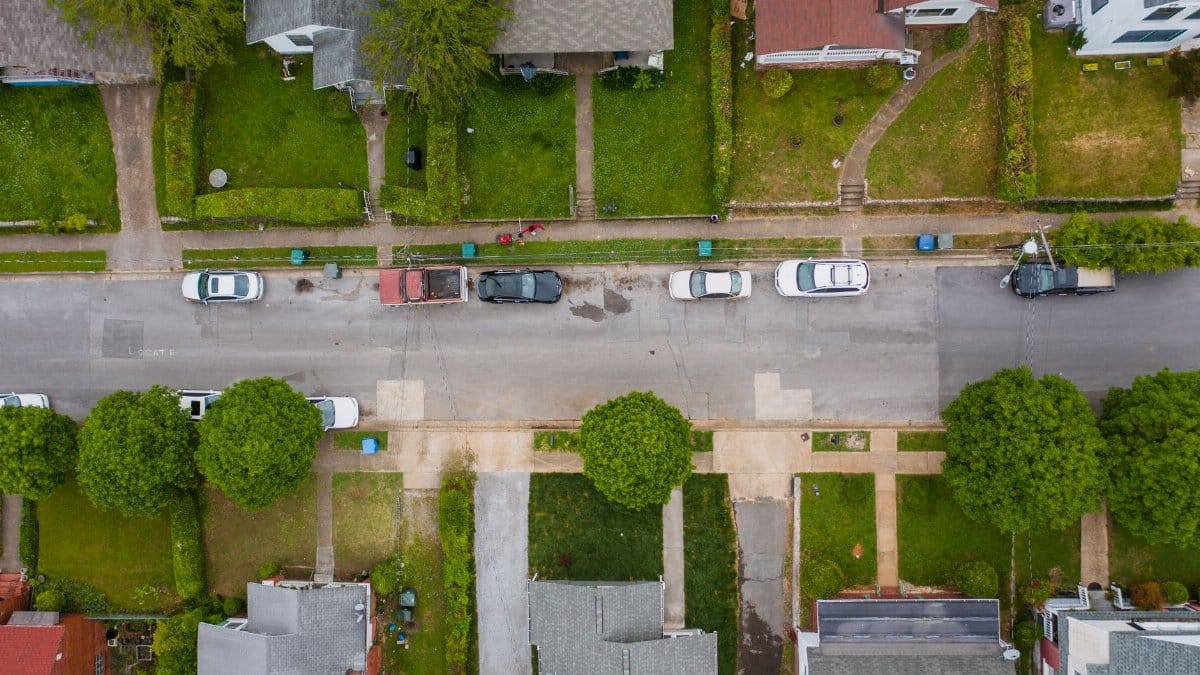 Top-down view of a suburban neighborhood showcasing parked cars and residential houses.