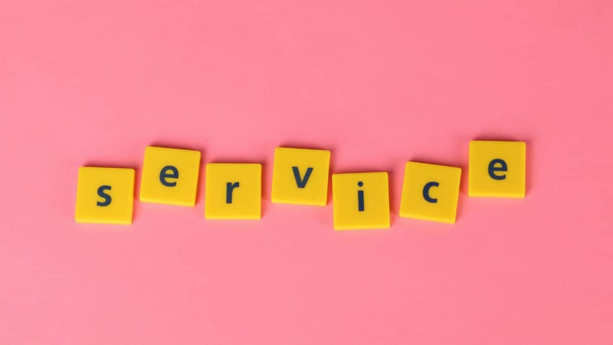 Yellow tiles spelling the word 'service' on a pink background, visually appealing design.