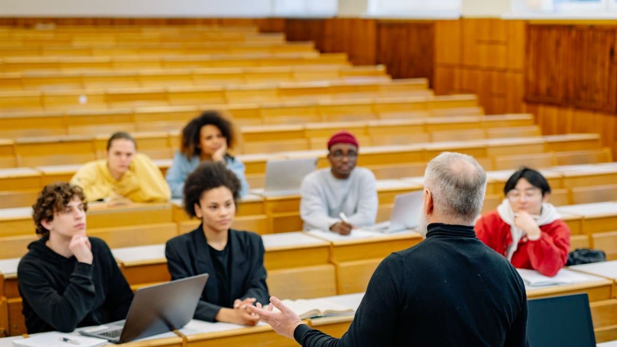 Students attending a lecture in a university classroom with an engaged professor.