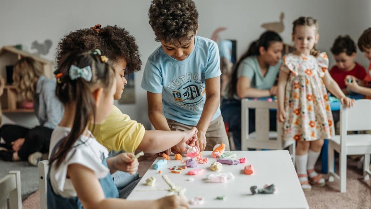 Young children playing with clay and learning together in a kindergarten classroom.