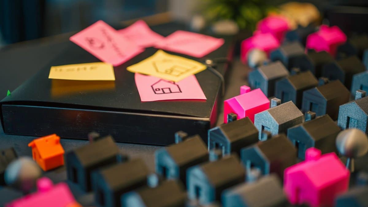 A vibrant display of miniature houses and sticky notes, illustrating real estate planning concepts.