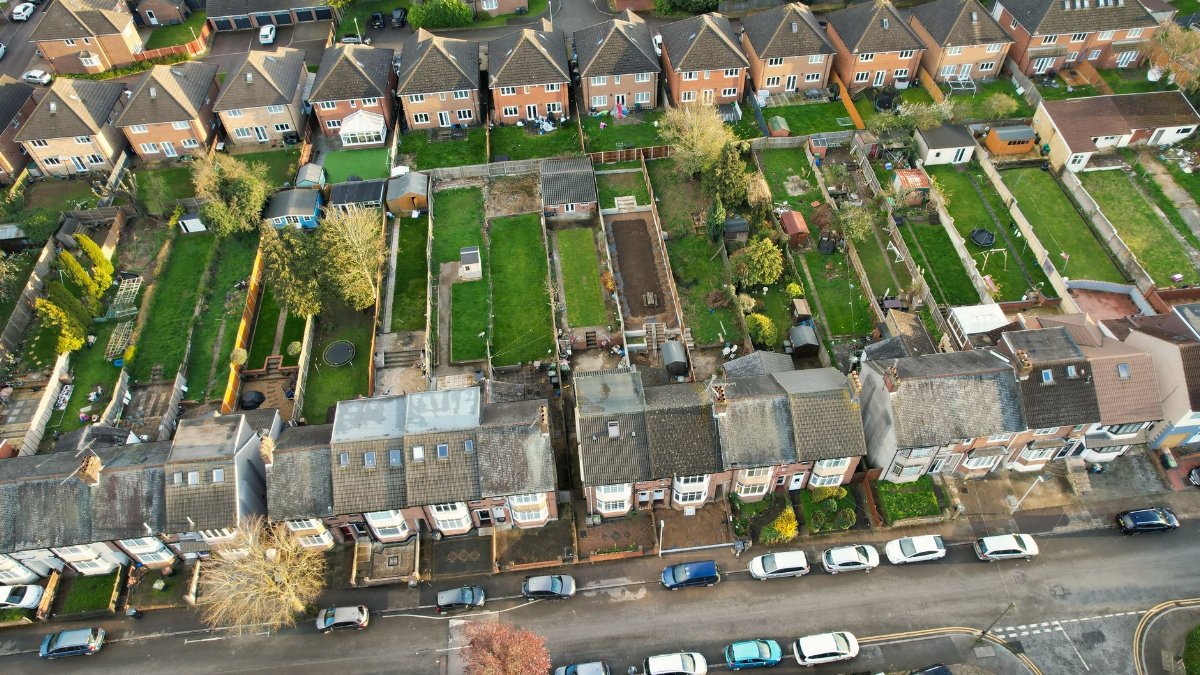 High-angle aerial shot of a residential neighborhood in Luton, UK, showcasing houses and gardens.