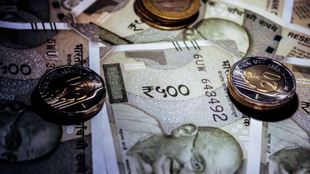 Detailed close-up of Indian currency notes and coins, featuring Mahatma Gandhi portrait.