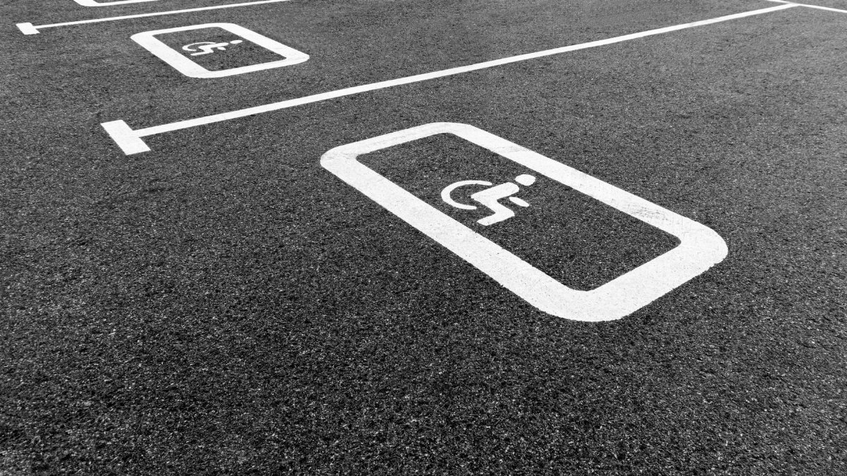 A black and white photo of a parking lot highlighting a disabled parking space.