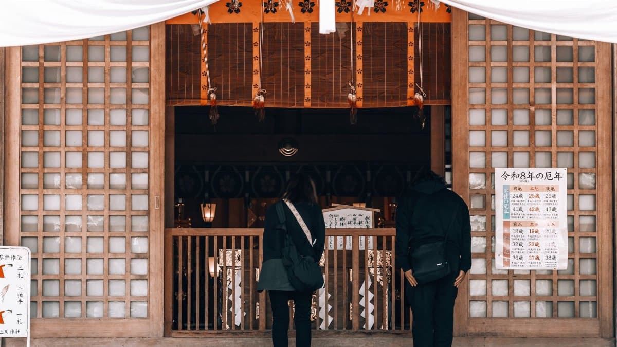 Visitors at a Japanese temple in Hokkaido, offering a glimpse into cultural practices.