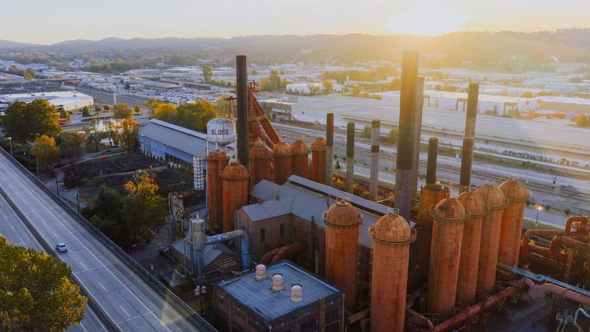 Aerial view of historic Sloss Furnaces in Birmingham, Alabama during sunset, showcasing industrial architecture.