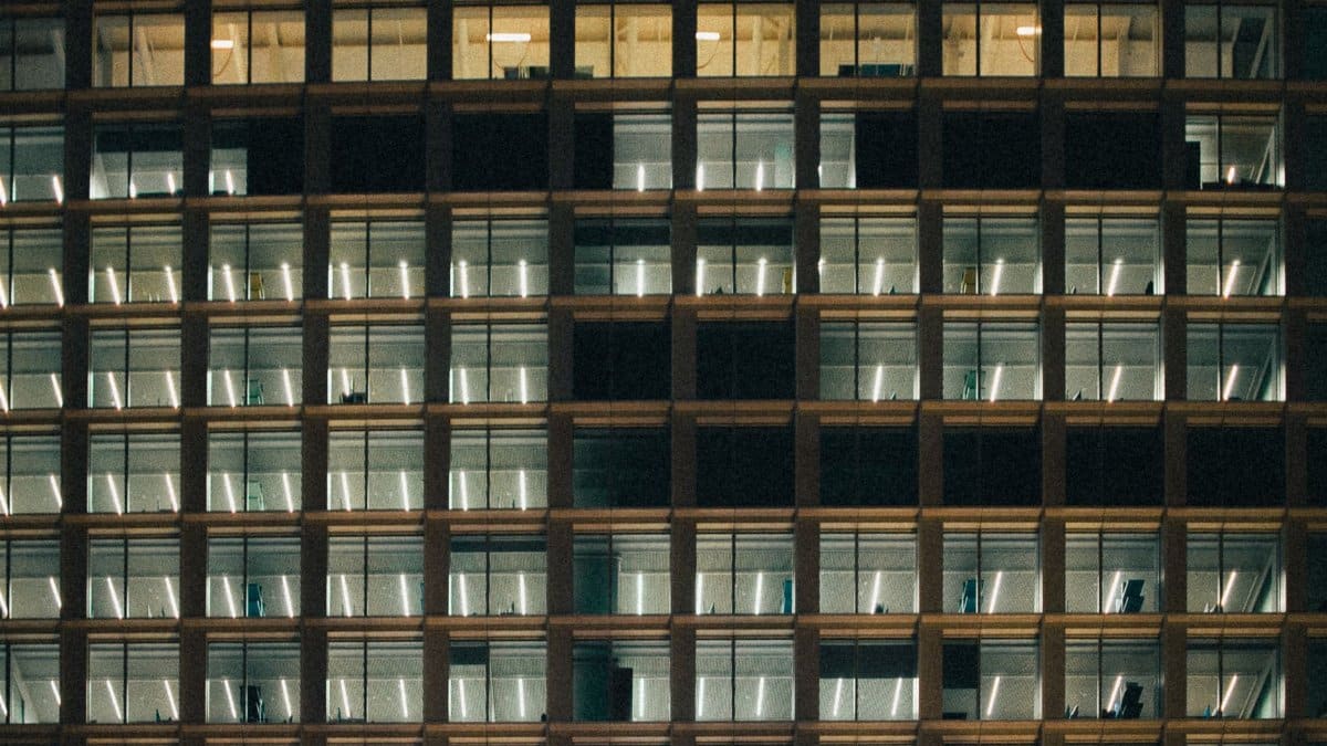 Symmetric facade of an office building at night with glowing interiors.