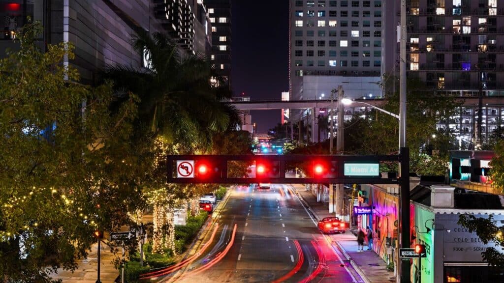 Vibrant night scene of South Miami Avenue with light trails and illuminated buildings.