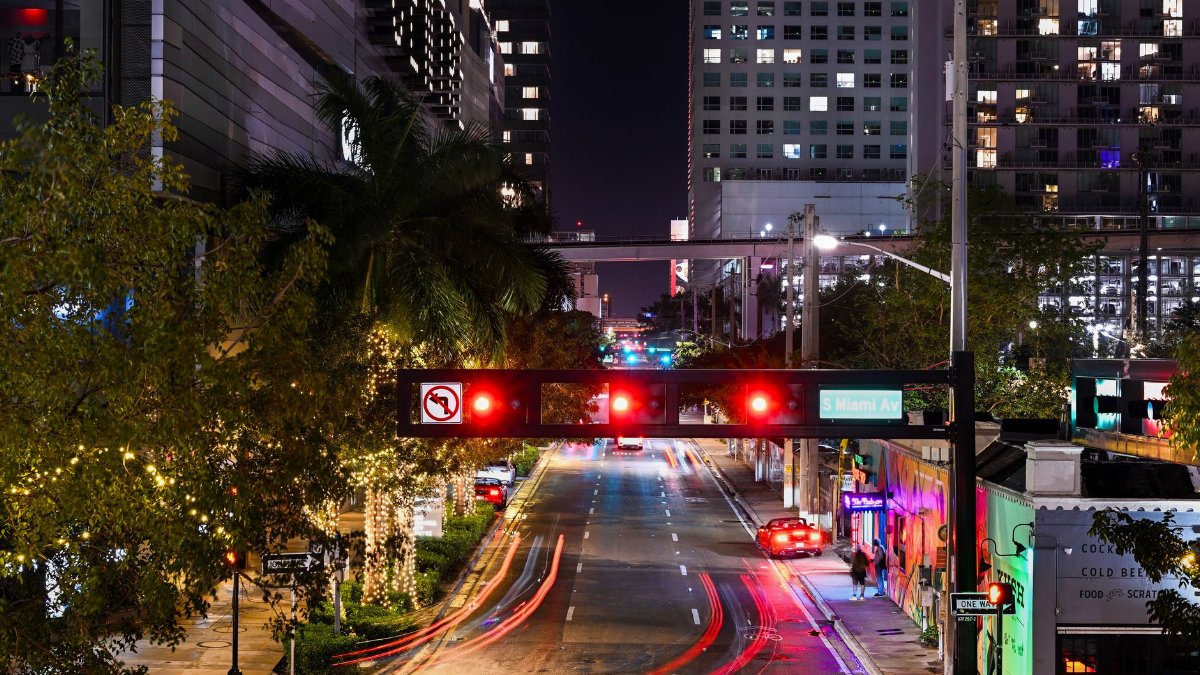Vibrant night scene of South Miami Avenue with light trails and illuminated buildings.