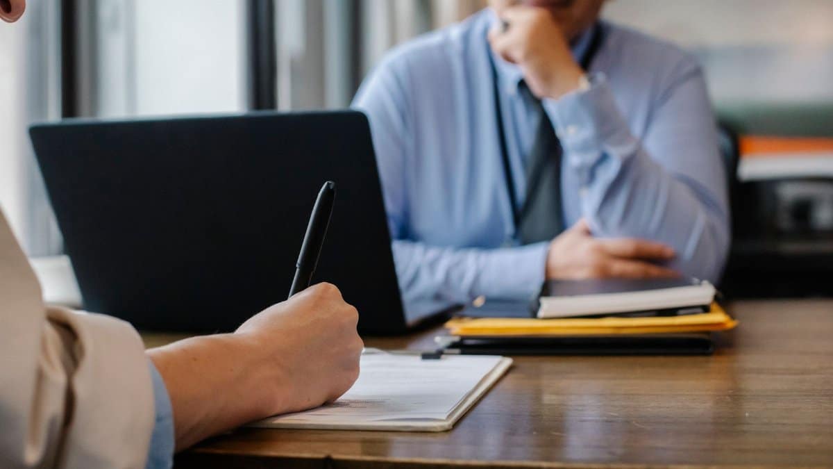 Crop anonymous female filling questionnaire when applying for job sitting in employer office