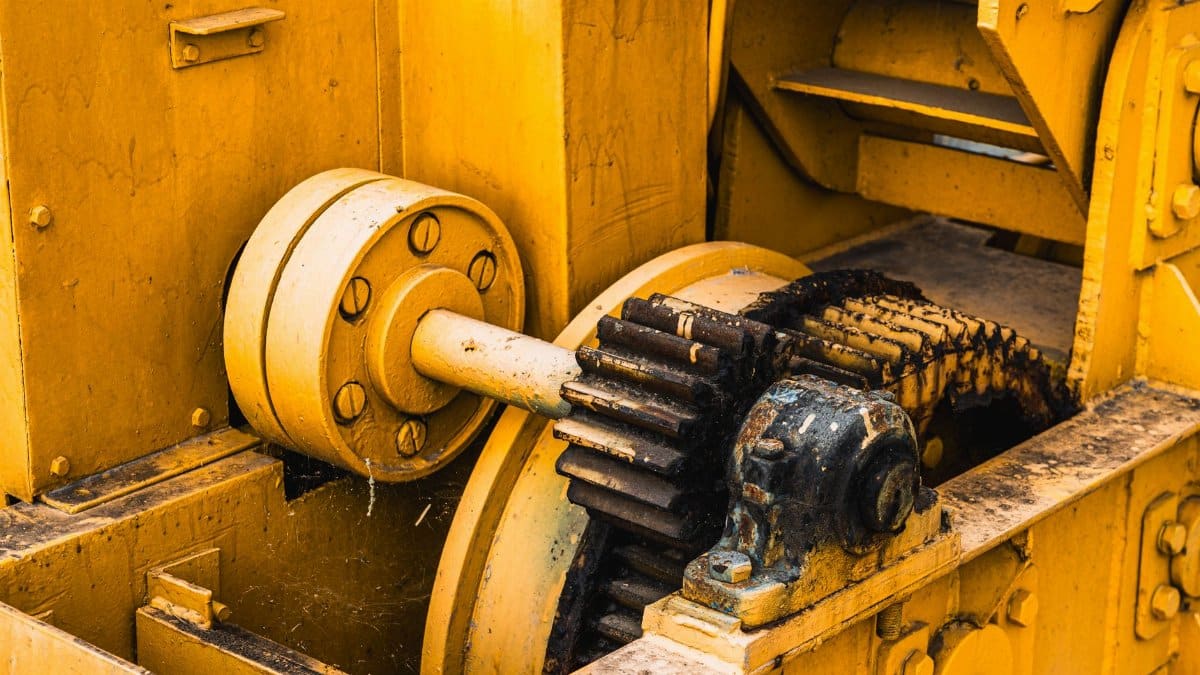 Detailed view of industrial machinery showcasing yellow painted metal gears and components.