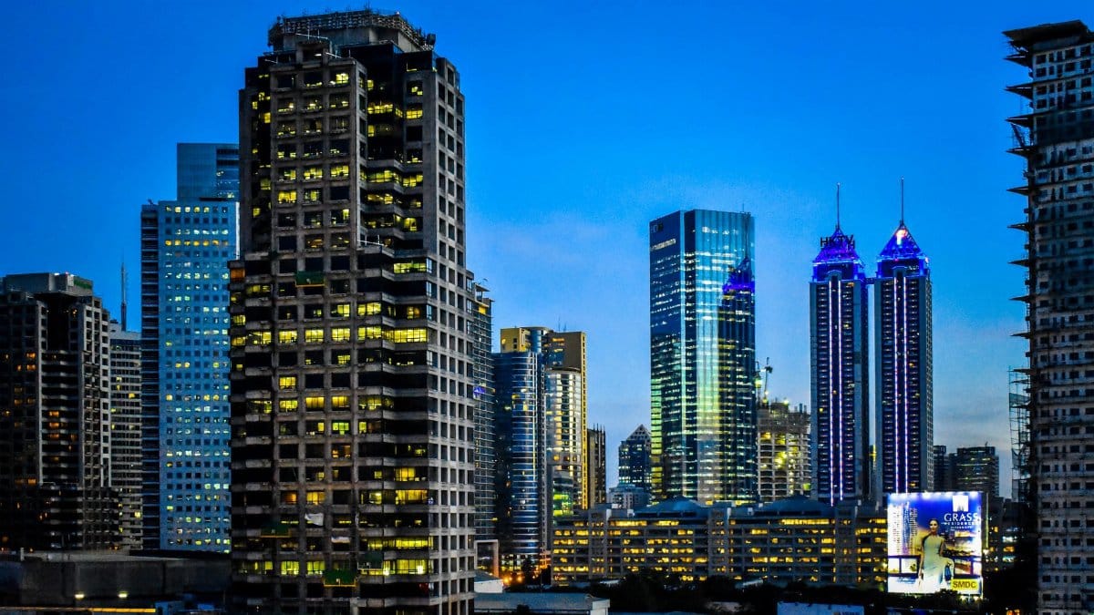 Illuminated skyscrapers at night in Pasig City, Philippines, showcasing modern architecture.