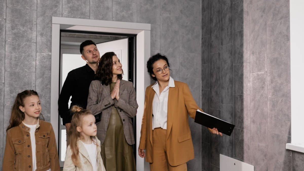 A family with children tours a new house guided by a realtor. Ideal for real estate themes.