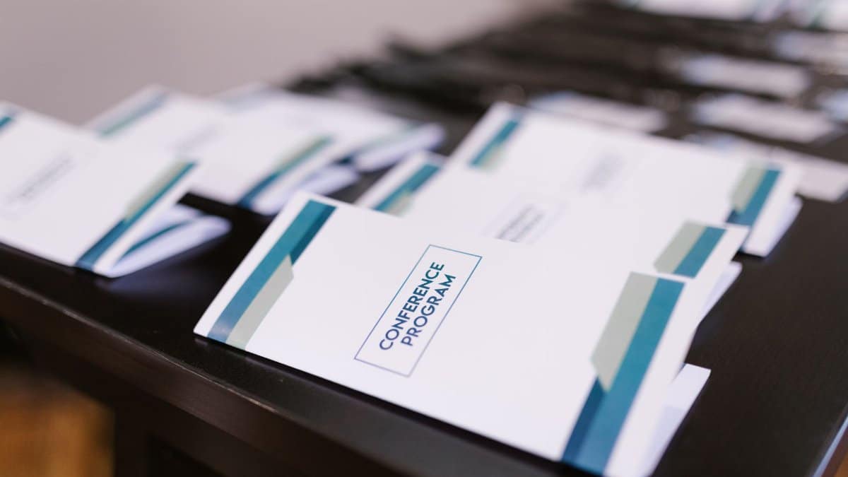 Close-up of conference program booklets neatly arranged on a table, indoors.