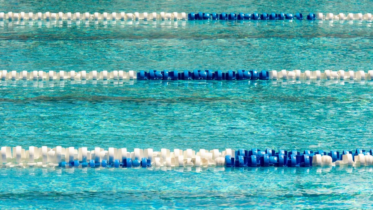 Vibrant swimming pool with blue and white lane dividers, ideal for competitions.