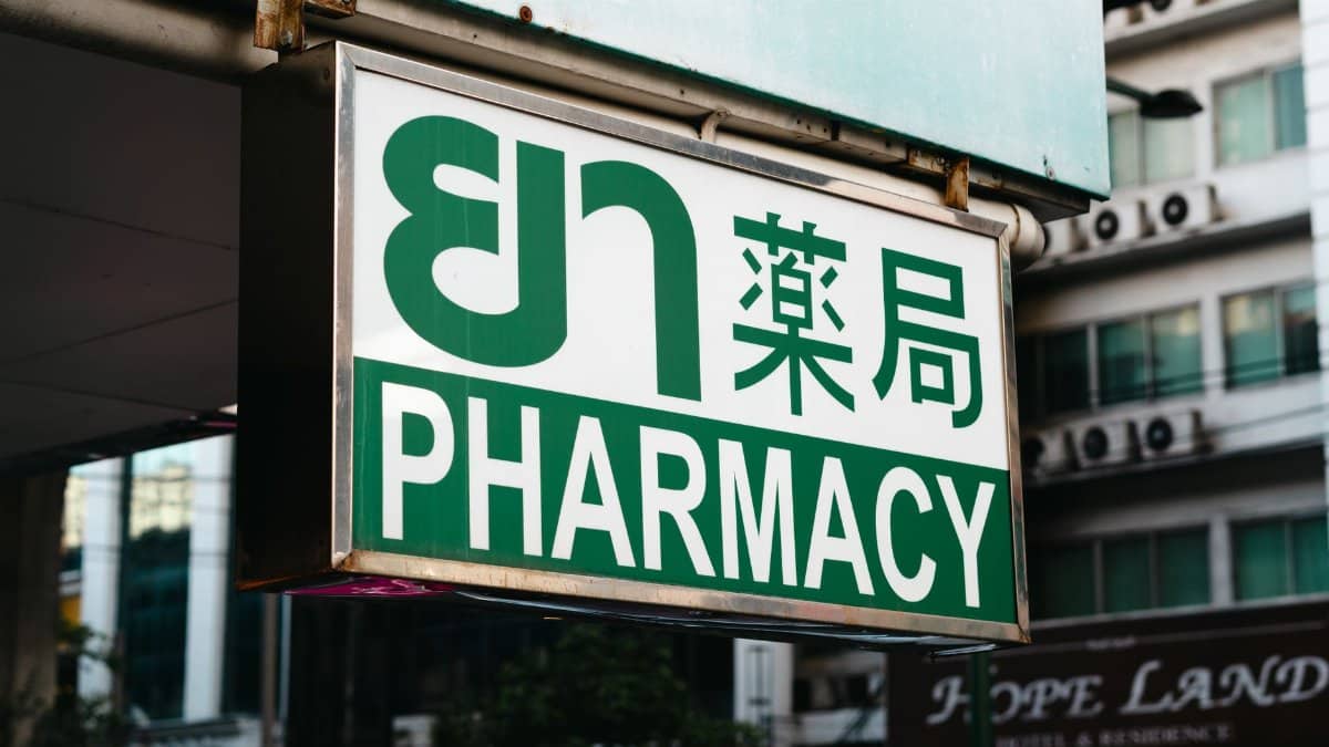 Outdoor street view of a pharmacy sign in Bangkok, Thailand.
