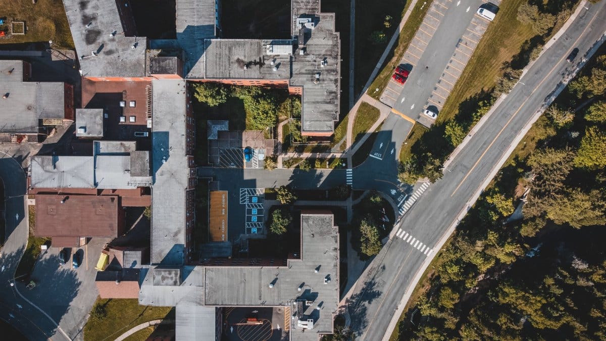 High-angle view of urban buildings, roads, and parking areas captured in daylight.