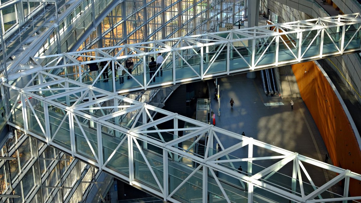 Explore the intricate architecture of a modern building in Tokyo, featuring glass facades and steel walkways.