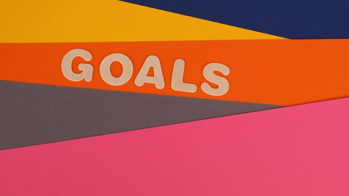 Vibrant abstract image with the word 'Goals' on multi-colored paper background.