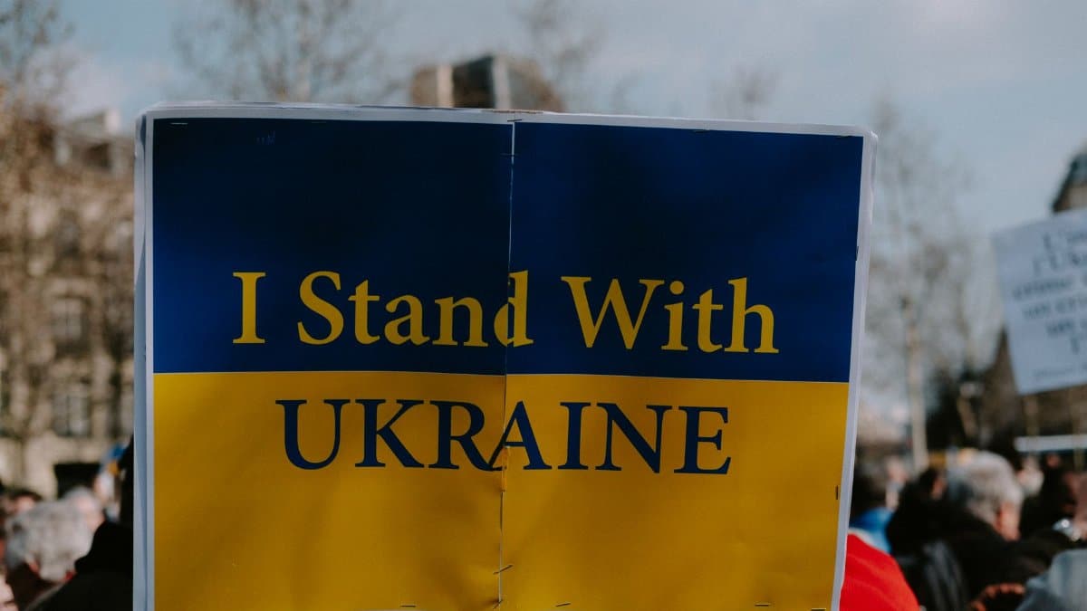 A protest image with a sign reading 'I Stand With Ukraine', showing solidarity and support.