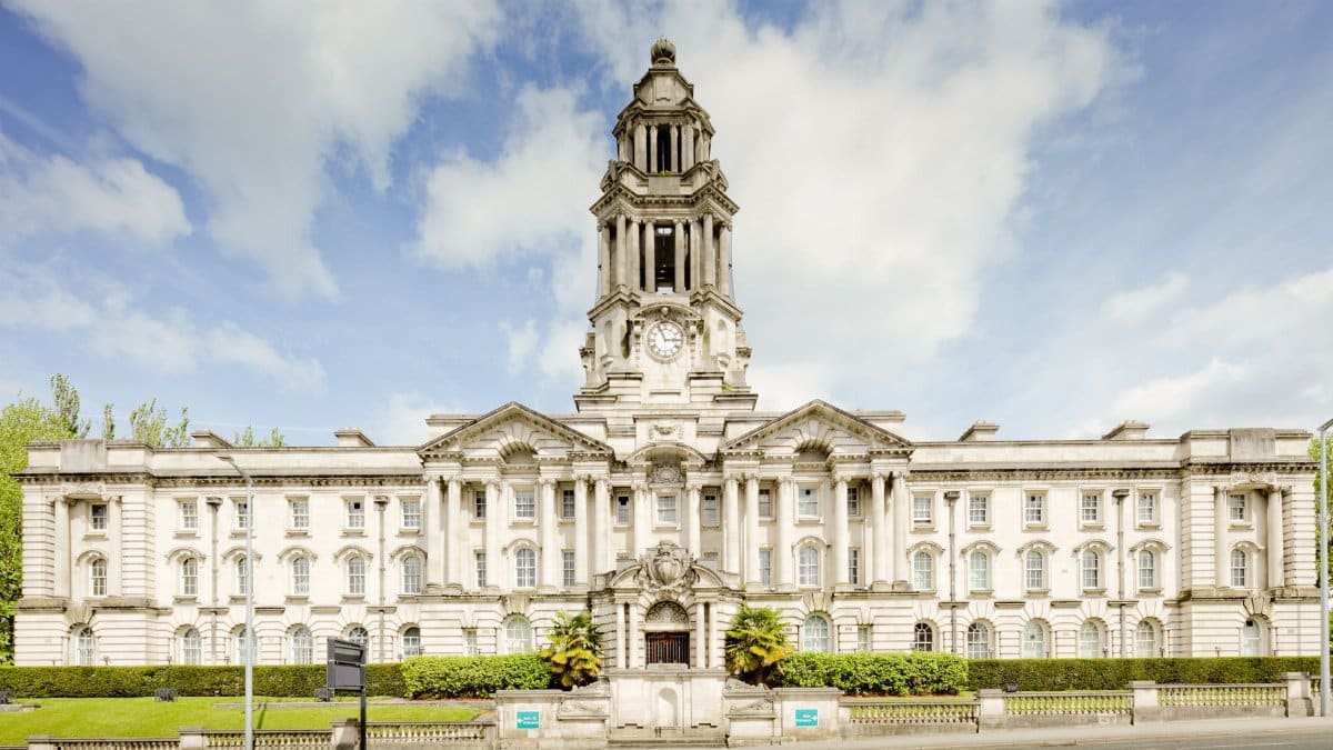 Front view of the iconic Stockport Town Hall with a clear blue sky backdrop.