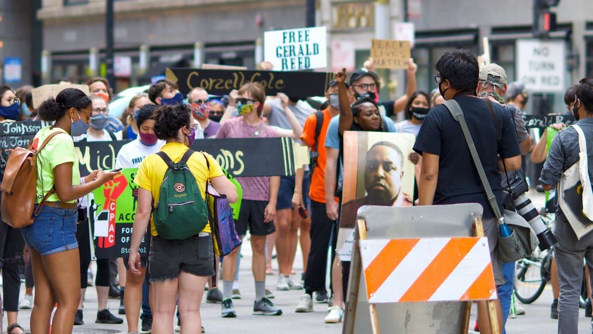 A diverse group of protesters gather peacefully in a city, advocating for justice reform.