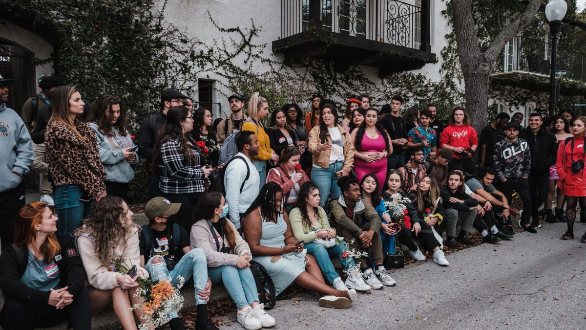 A large group of diverse people gathered outdoors in Winter Park, FL, showcasing community and togetherness.