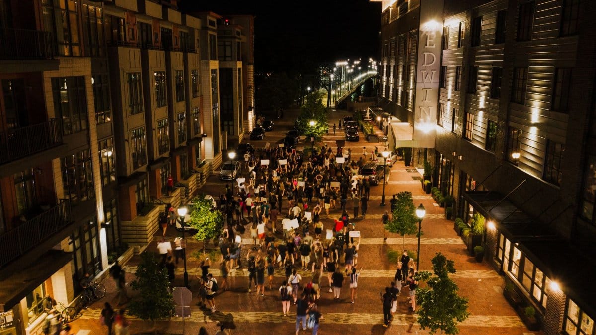 High angle of people with placards advocating for rights during protests in city at night