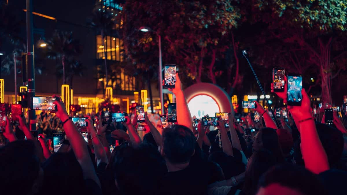 A vibrant crowd in Taguig capturing nightlife with smartphones. Perfect for social media and urban lifestyle themes.