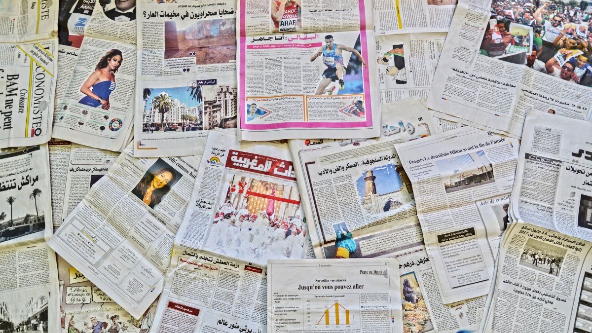 A vibrant array of newspapers laid out in Fès, showcasing diverse stories.