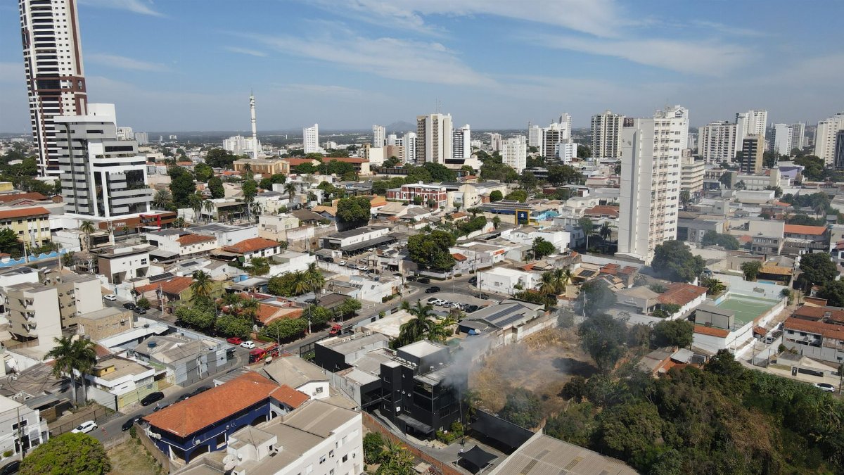 Aerial image capturing a small urban fire in Mato Grosso, highlighting cityscape and emergency response.