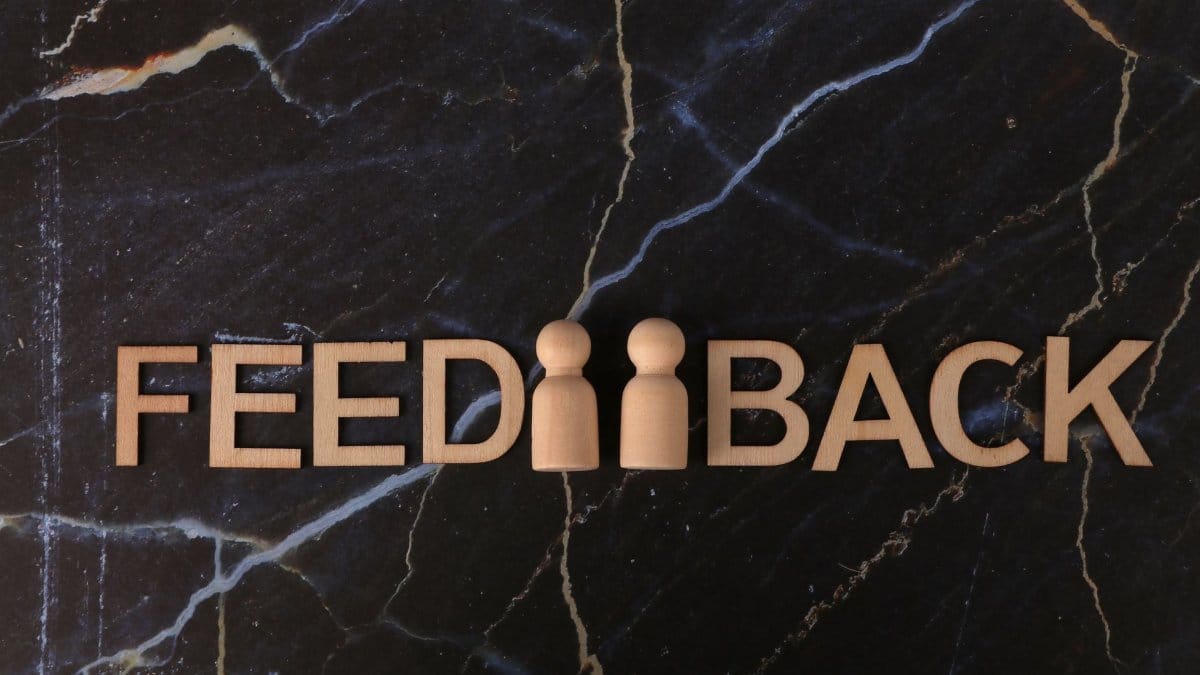 Feedback concept with wooden letters on a dark marble surface.