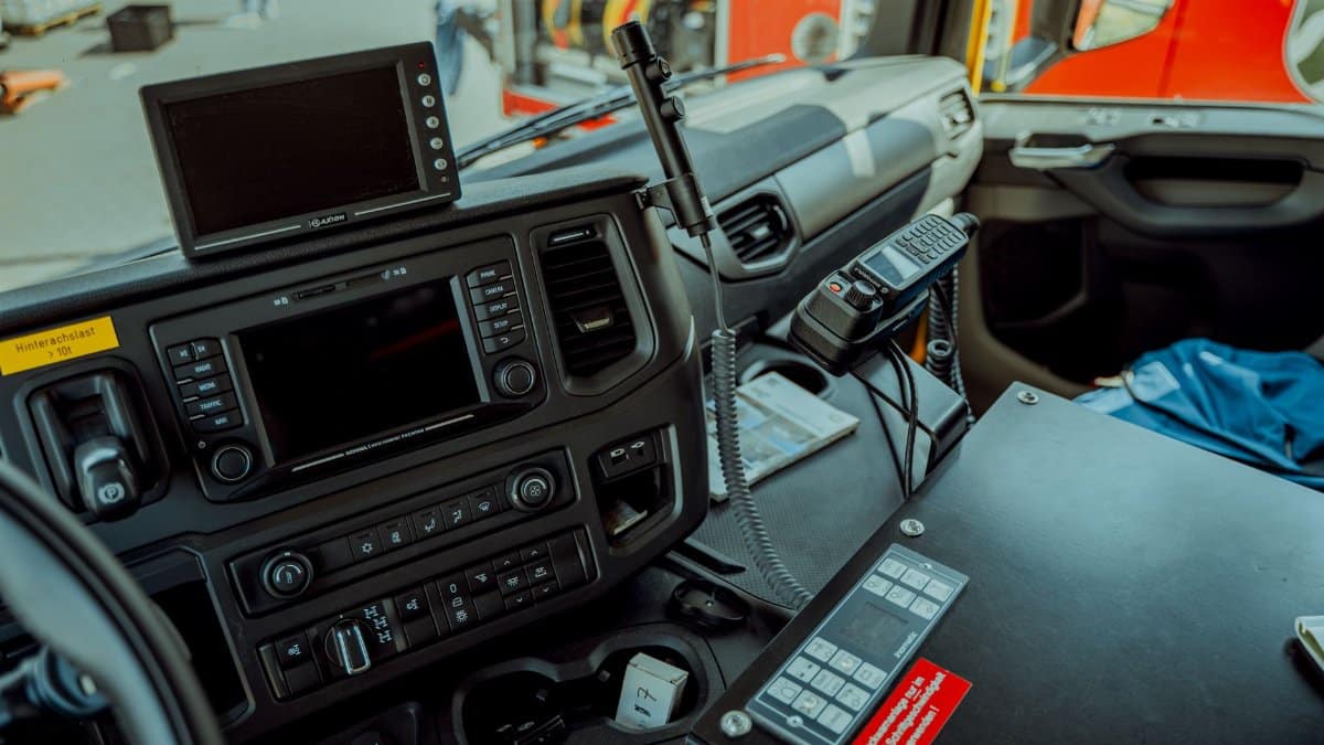 Detailed photo of a firetruck dashboard with communication devices and navigation screens.