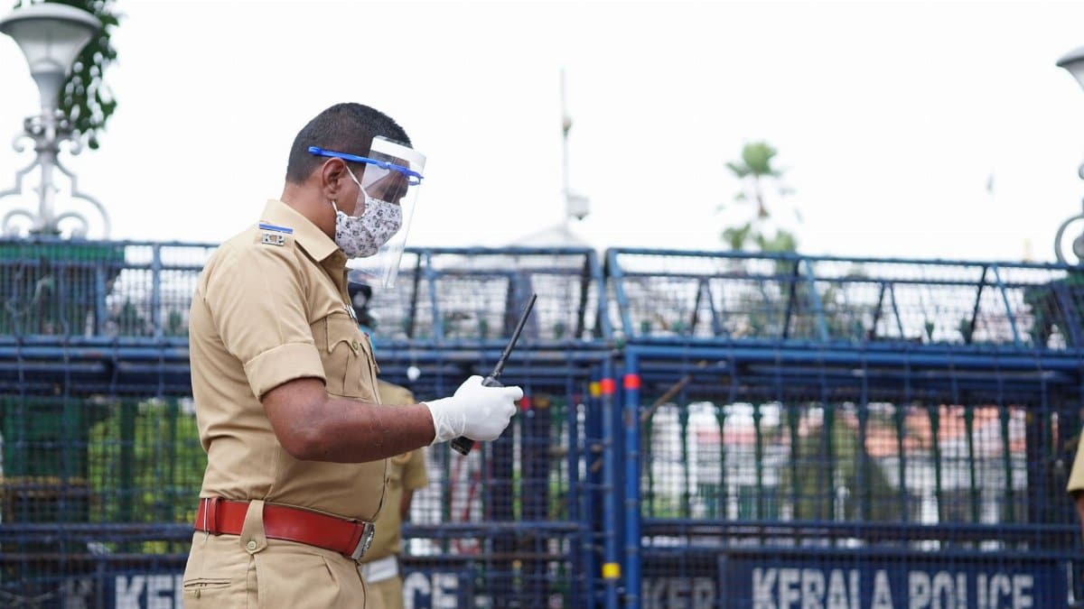 A police officer in Kerala, India, equipped with safety gear, focuses on public security.