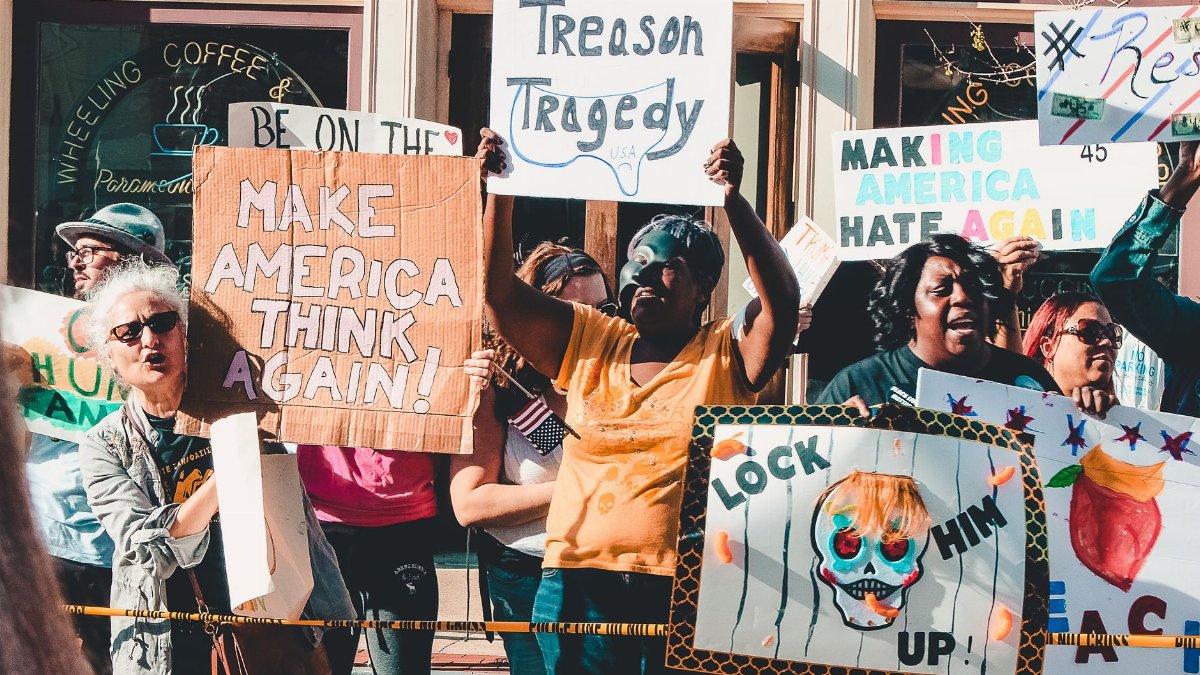 A lively street protest advocating political change with diverse participants and creative signs.