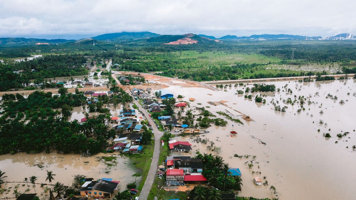 Aerial shot showing flood-affected village in Kijal, Malaysia, surrounded by water and greenery.