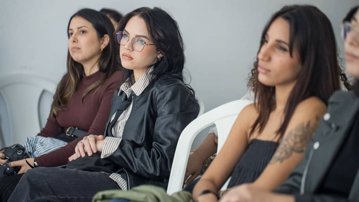 Focused individuals attending an indoor seminar, showcasing engagement and learning.