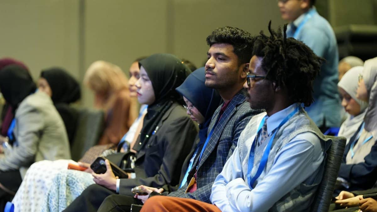 Attendees seated attentively at a professional business conference indoors.